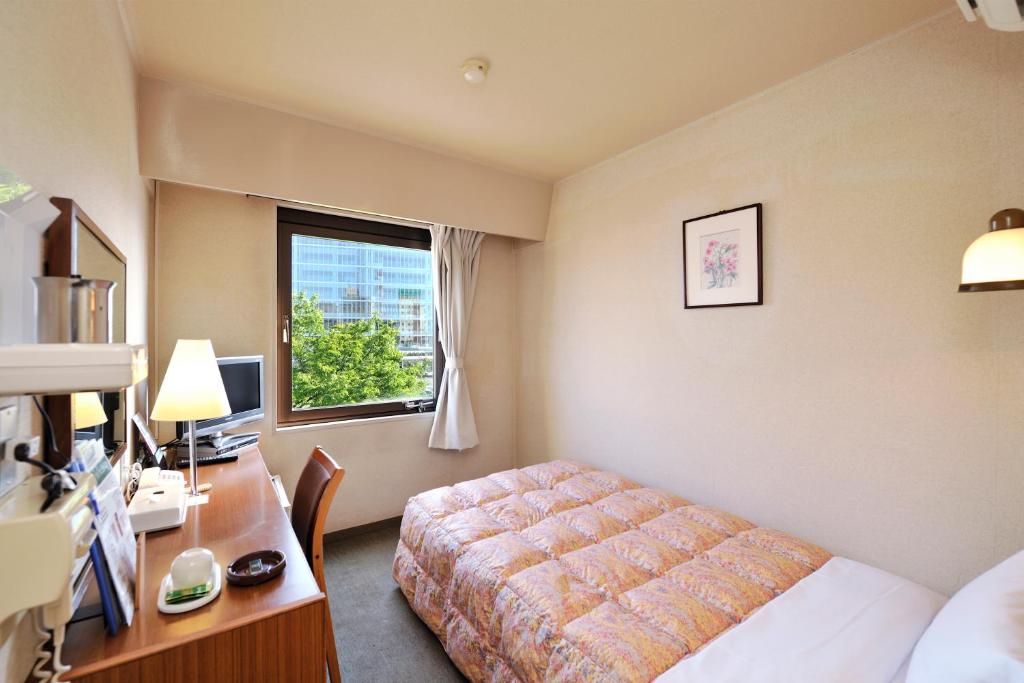 Postel nebo postele na pokoji v ubytování Hotel Keifuku Fukui Ekimae
