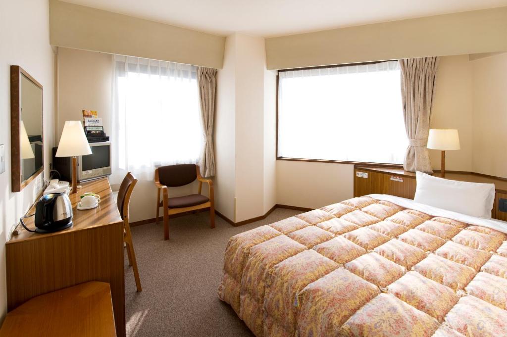 Postel nebo postele na pokoji v ubytování Hotel Keifuku Fukui Ekimae