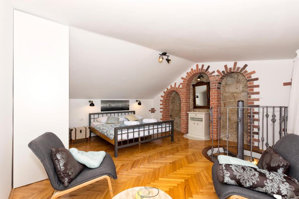 a bedroom with a bed and a brick wall at Old Split Apartment in Split