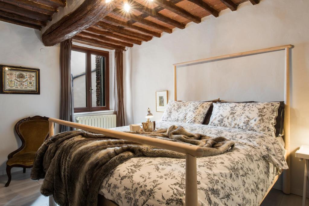 um quarto com uma cama grande e uma grande cabeceira. em San Carlo Apartment em Lucca