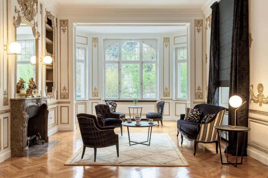 sala de estar con sillas, mesa y chimenea en Villa Camoufle, en Metz