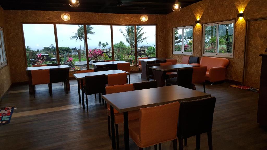 a restaurant with tables and chairs and windows at Gajilia B&B in Chenggong