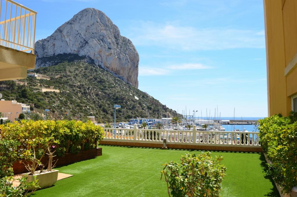a view of a mountain from a building with a green lawn at Hotel Porto Calpe in Calpe