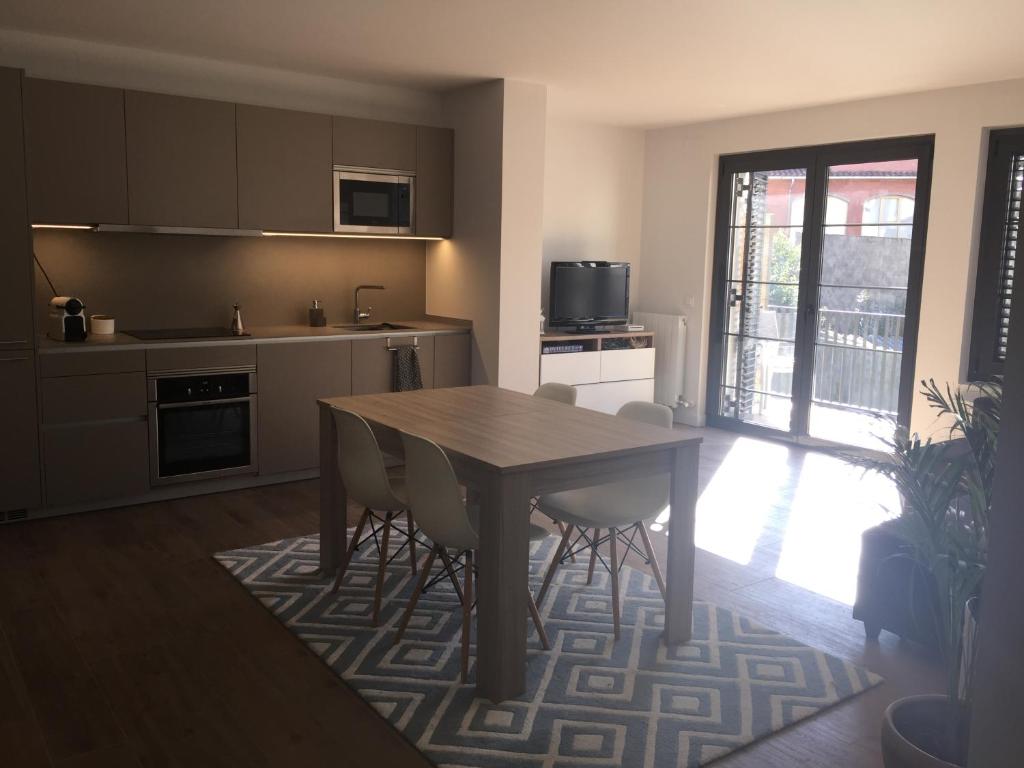 - une cuisine avec une table et des chaises dans la chambre dans l'établissement APARTAMENTO CÉNTRICO EN OLOT, à Olot