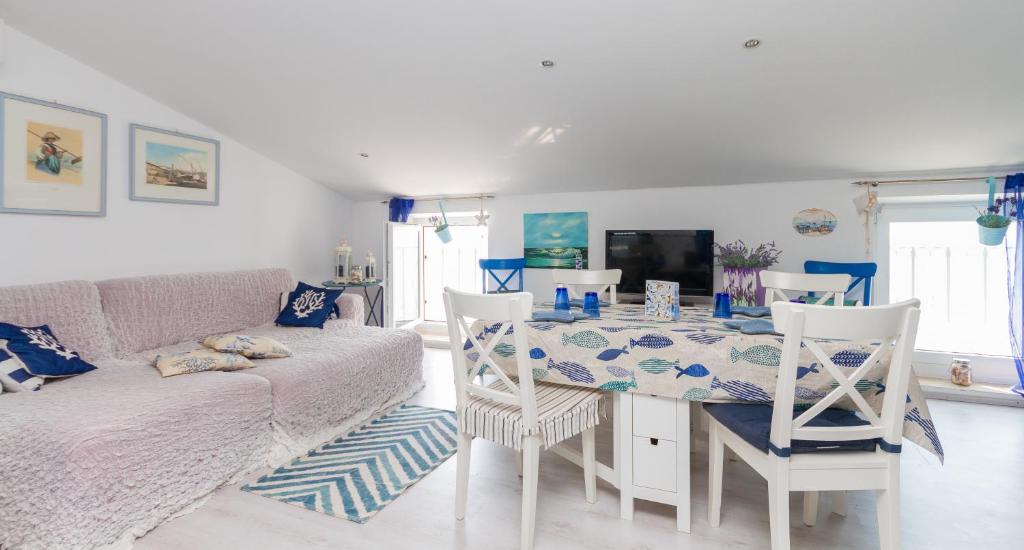a living room with a table and a couch at Blue Sea Apartment by Locap Group in Piran
