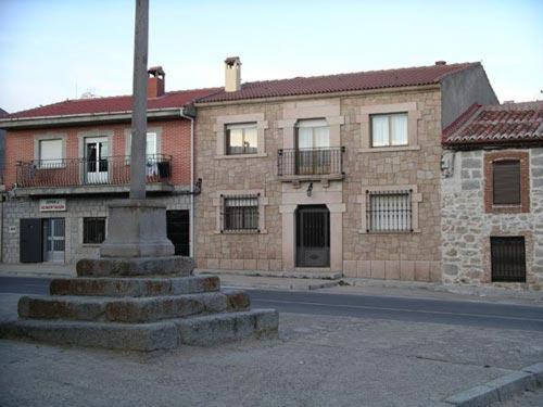 a building with a pole in the middle of a street at Casa Rural de Tio Tango II in Cardeñosa