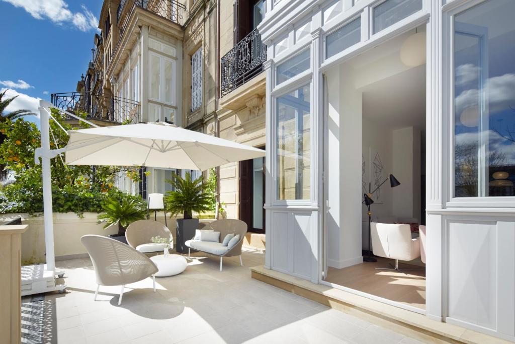 a patio with an umbrella and chairs and a table at La Dolce Vita by FeelFree Rentals in San Sebastián