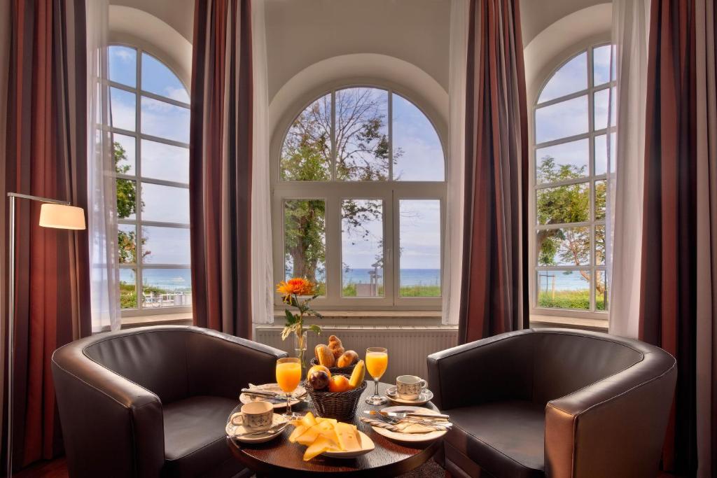 ein Esszimmer mit 2 Stühlen und einem Tisch mit Obst in der Unterkunft Strandhotel Binz in Binz