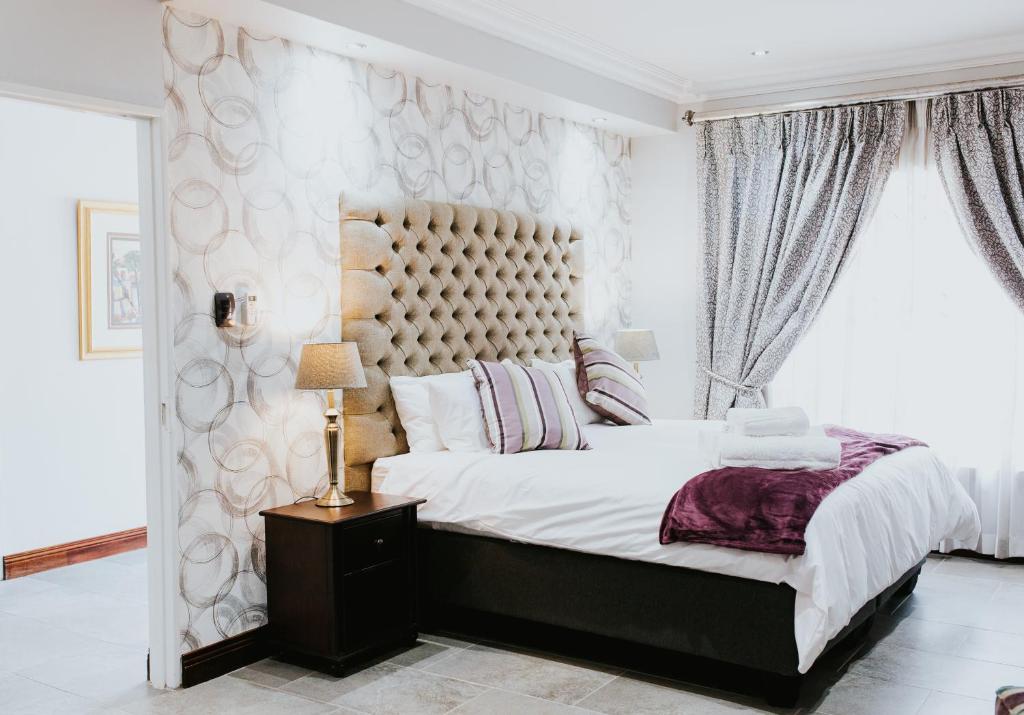 um quarto com uma cama grande e uma janela grande em Iso'Bella Vita Guesthouse em Phalaborwa