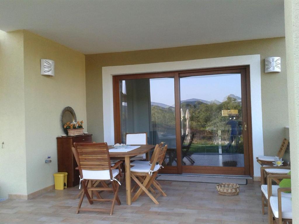 a dining room with a table and chairs and a window at monte moro in Arzachena