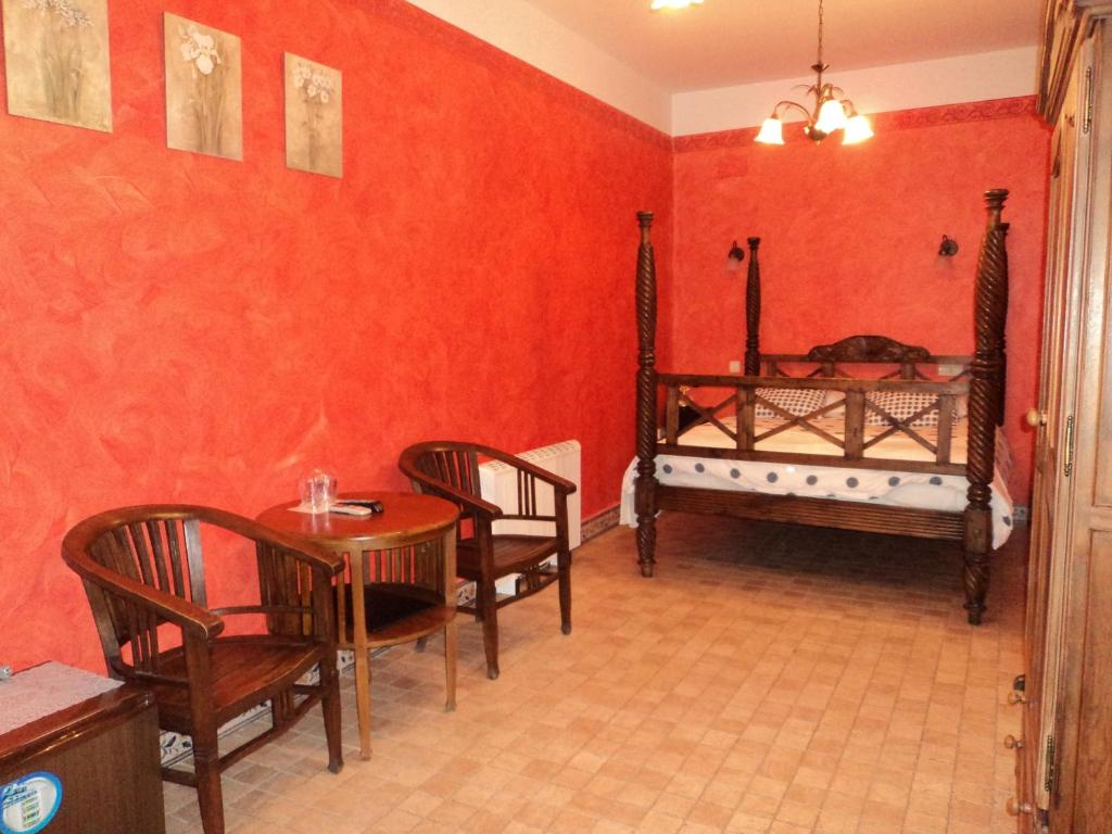 セゴビアにあるオステリア ナトゥラのテーブル、椅子、ベッドが備わる客室です。