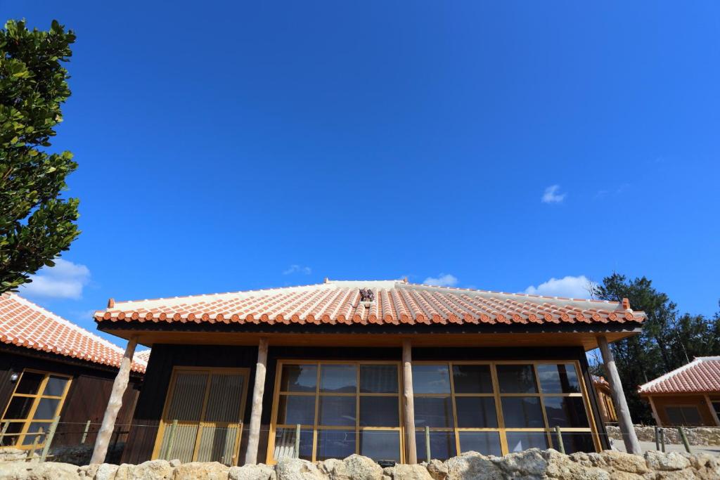 una casa con techo de azulejos encima en Tabinoteitaku Okinawa Nakijin HOMANN CONCEPT, en Nakijin