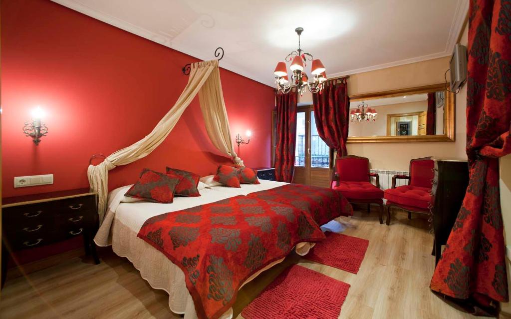 1 dormitorio rojo con 1 cama y paredes rojas en Legado de Ugarte, Casa Rural en Laguardia