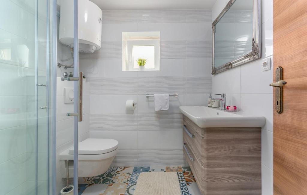a white bathroom with a toilet and a sink at Villa Stephany in Poreč