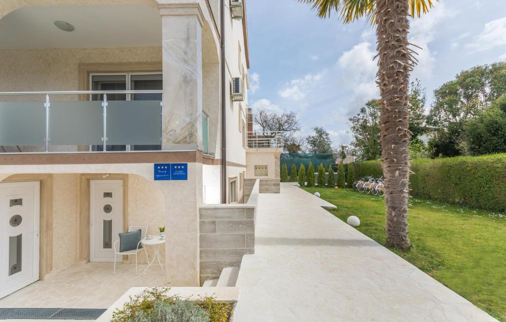 a house with a palm tree and a walkway at Villa Stephany in Poreč