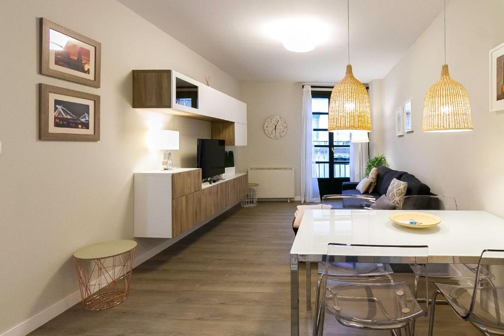 uma sala de estar com uma mesa e uma sala de estar com um sofá em Céntrico Burgas Termal em Ourense