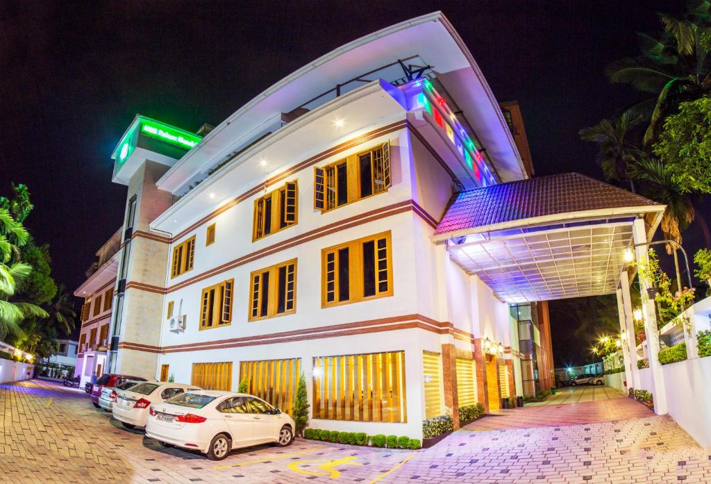 un edificio blanco con coches estacionados frente a él en Hill Palace Hotel & Spa, en Kochi