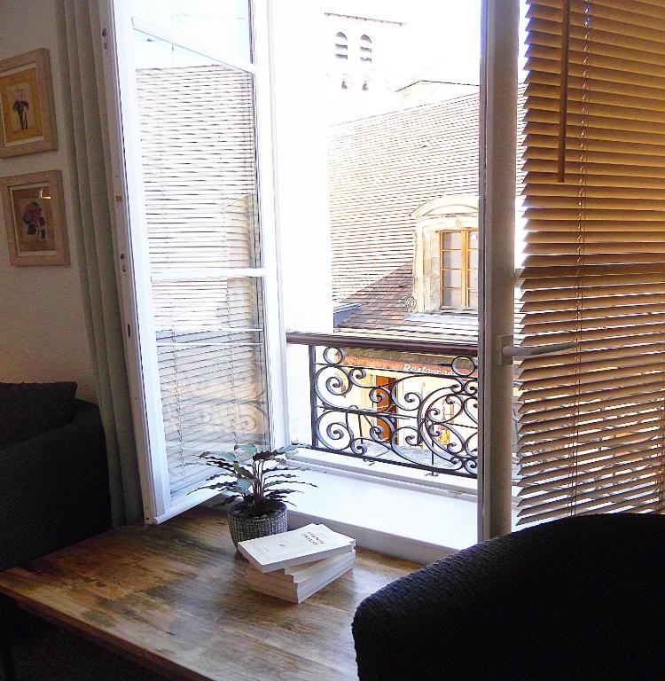 a living room with a view of a balcony at Tourny - Studio cosy Centre médiéval Sarlat in Sarlat-la-Canéda