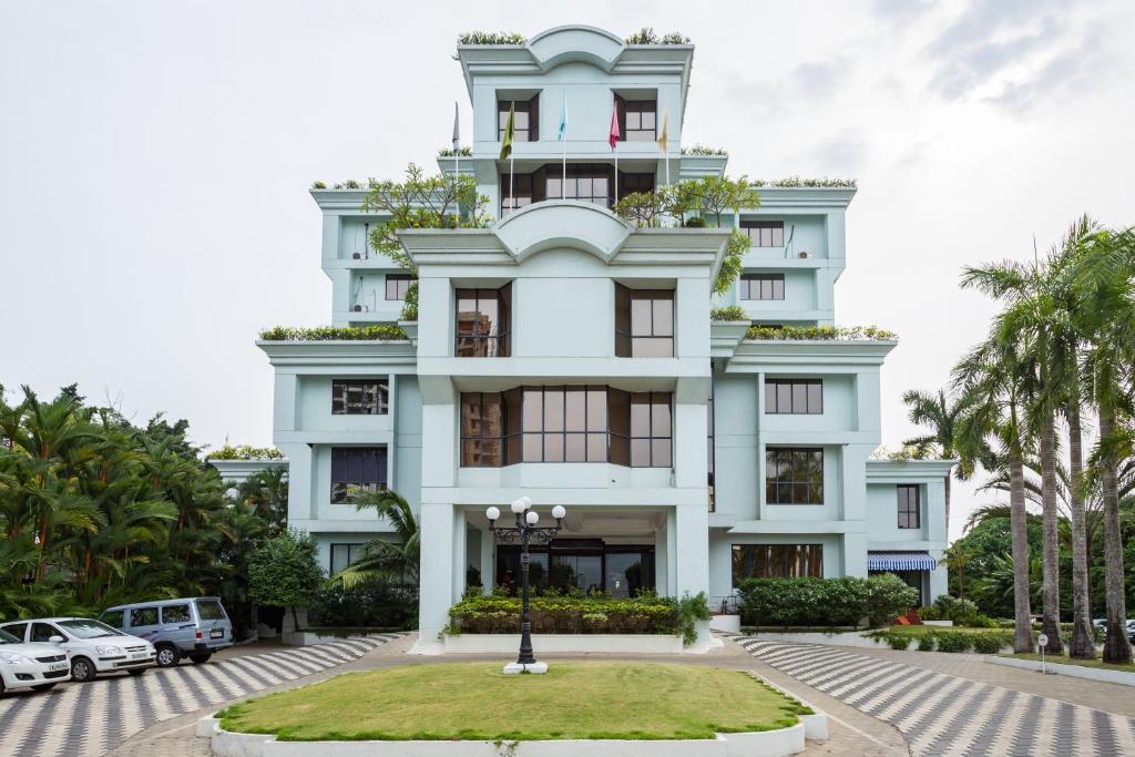 a white building with cars parked in front of it at The Windsor Castle in Kottayam