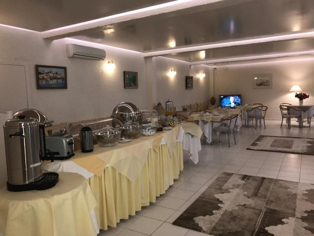 jadalnia ze stołami z białymi obrusami w obiekcie Sailor's Nautical Concept w mieście Spetses