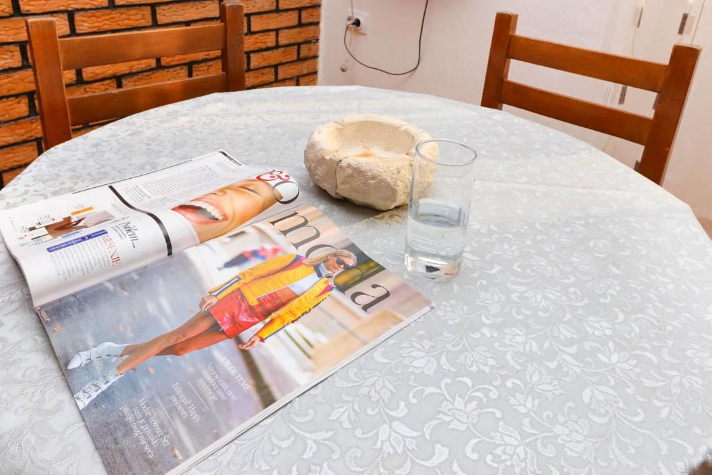a table with a magazine and a glass of water at Apartments Ivo Bozinovic in Tivat