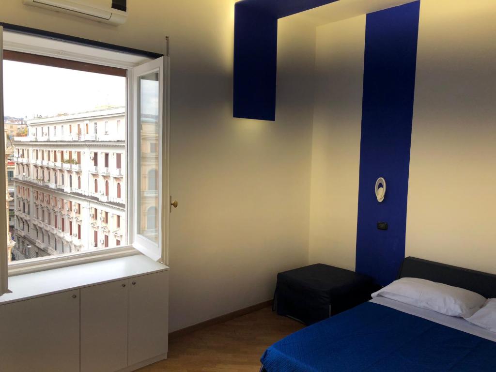 - une chambre avec un lit et une grande fenêtre dans l'établissement Maison Arena Bovio, à Naples