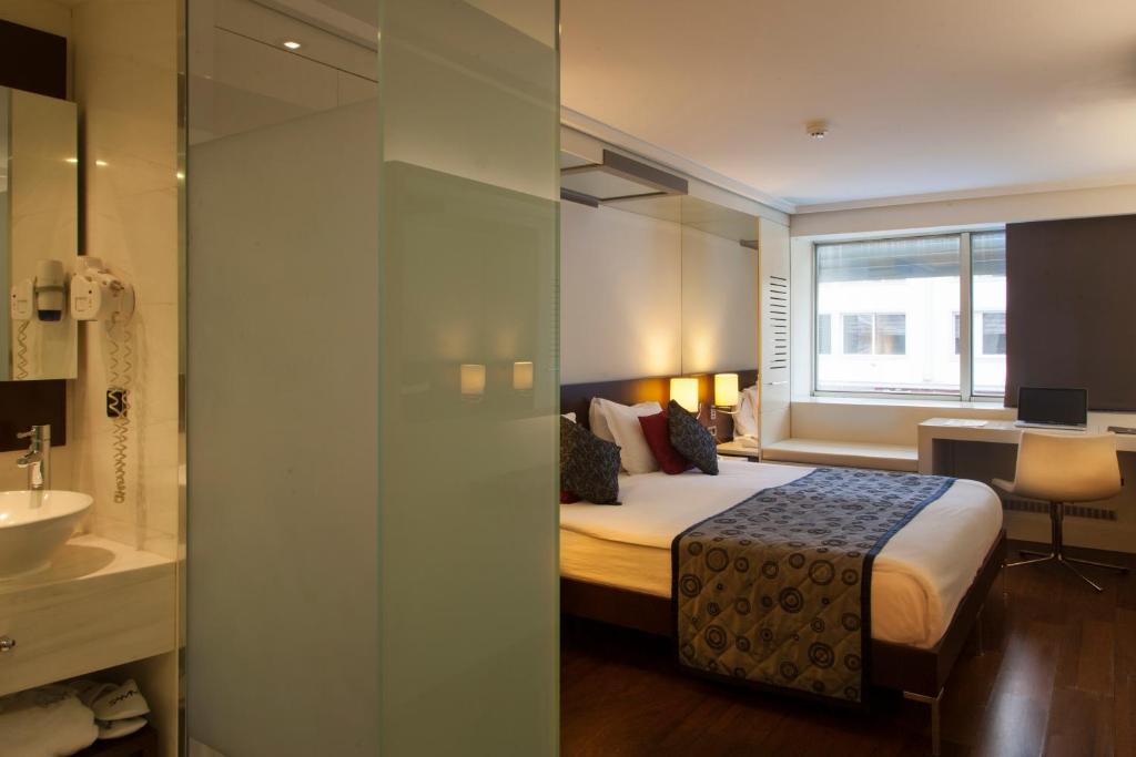 アンカラにあるHotel Samm Bistro Spaのベッドとシンク付きのホテルルーム
