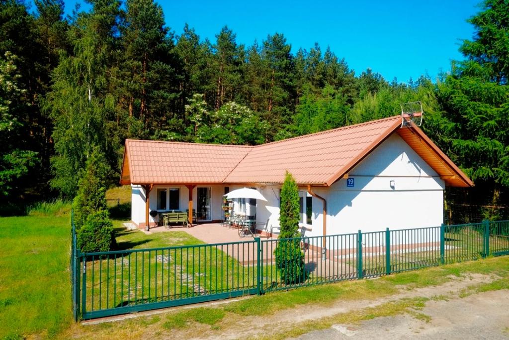 グダニスクにあるDomek Letniskowy Pod Lasemの赤屋根の小さな白い家