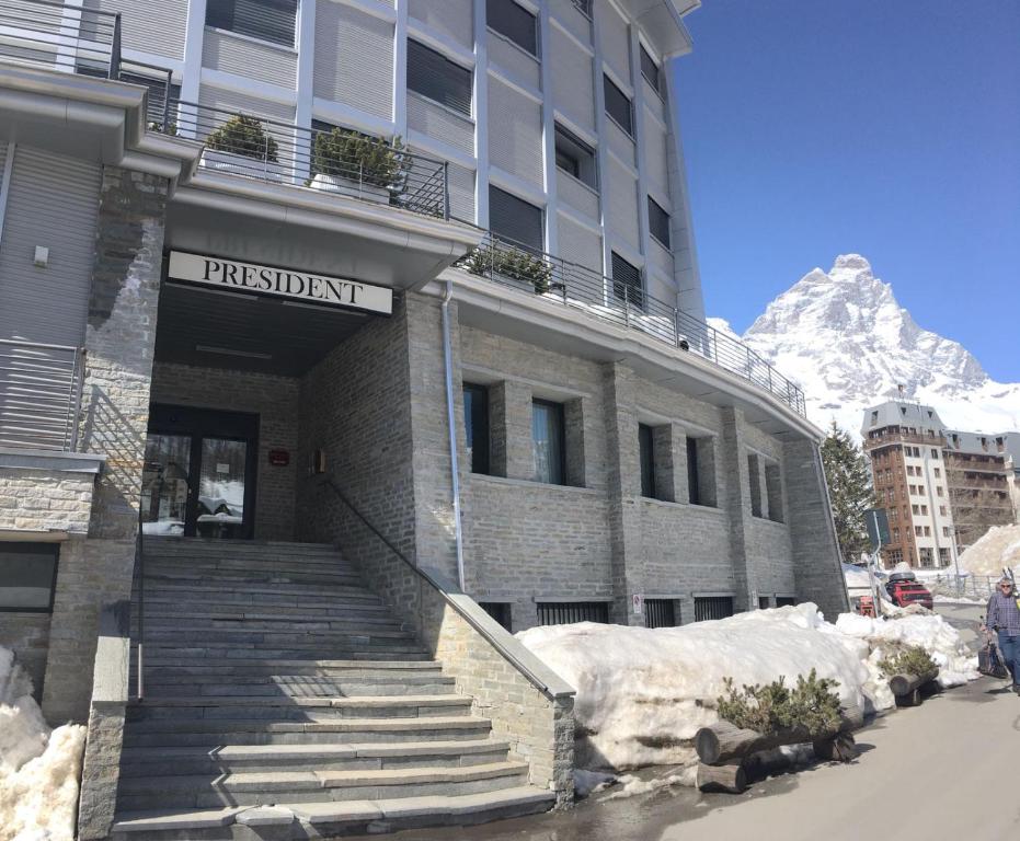 a building with stairs in front of a mountain at President Palace - Breuil Cervinia - 6 in Breuil-Cervinia