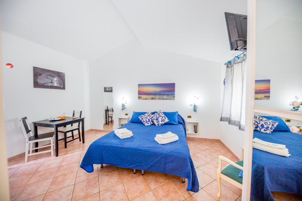 a room with two beds and a table in it at Casa Zaffiro in Cefalù