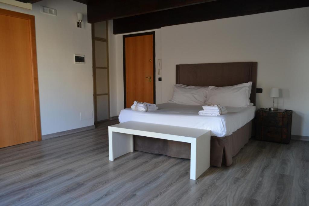 1 dormitorio con cama blanca y banco en Gatto Bianco le Dimore, en Bari