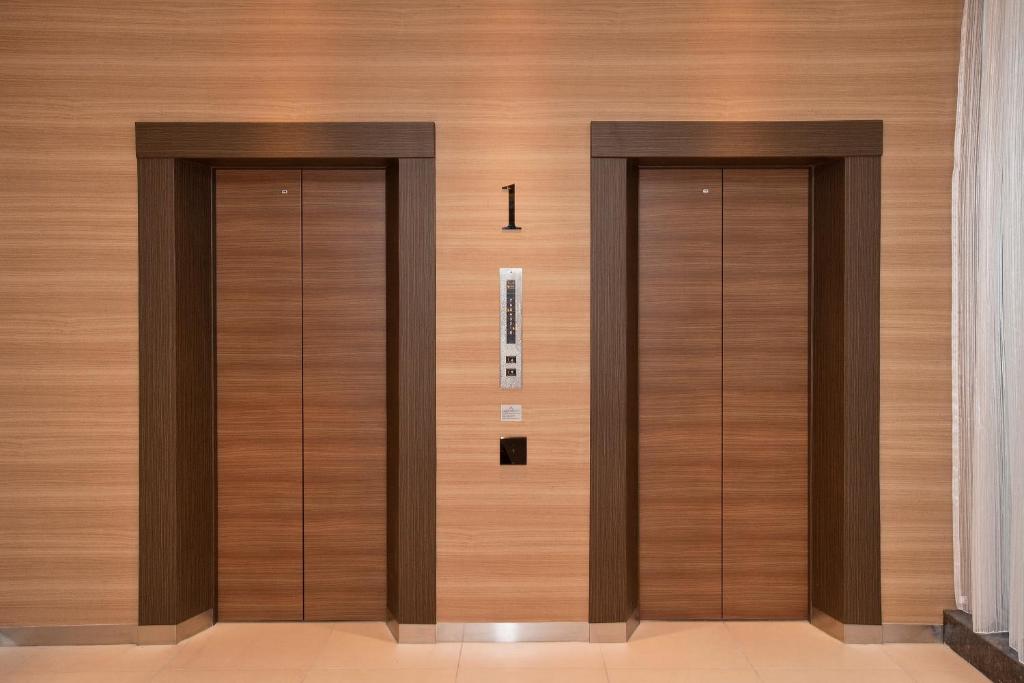 two elevators in a building with wooden walls at Sotetsu Fresa Inn Tokyo-Toyocho in Tokyo