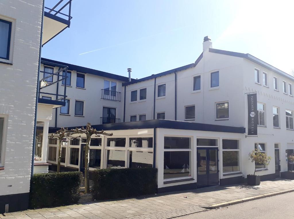 een groot wit gebouw met veel ramen bij Fletcher Hotel Valkenburg in Valkenburg