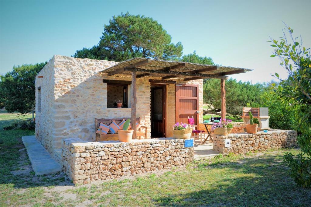 una pequeña casa de piedra con una pared de piedra en Siamoformentera Bella, en Sant Francesc Xavier