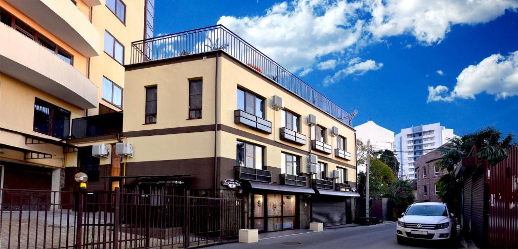 a white car parked in front of a building at Guest House on Lermontova 8 in Sochi