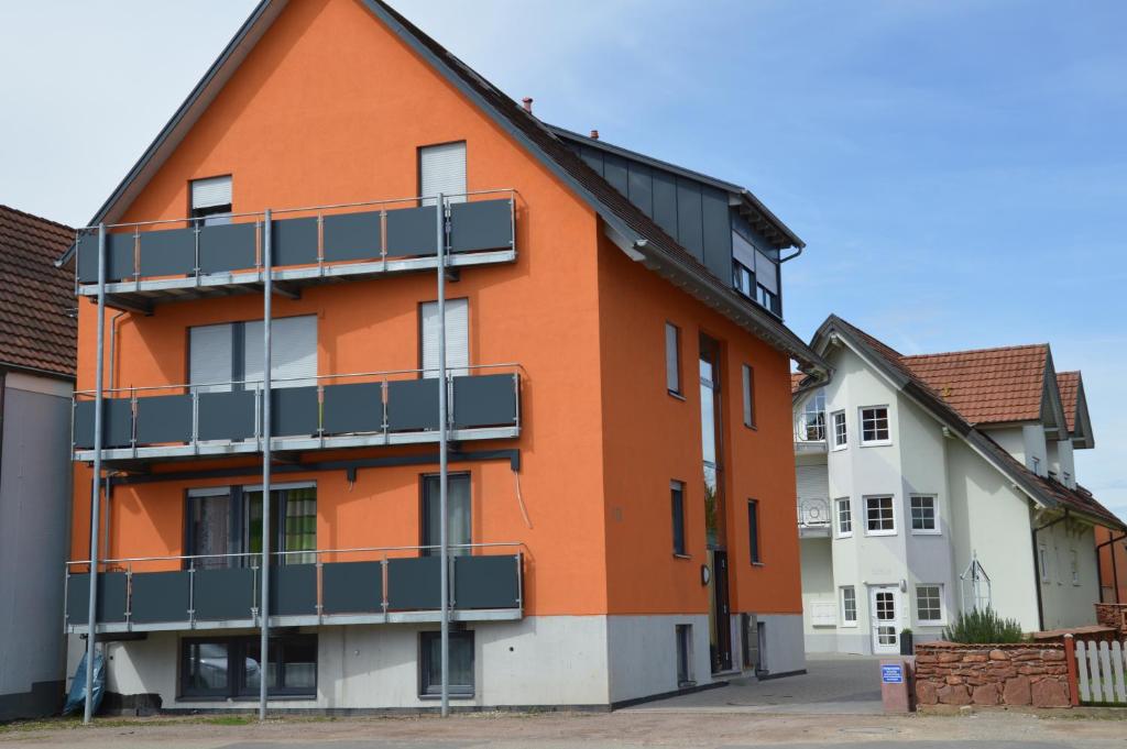 un edificio anaranjado con balcones en el lateral. en Ferienwohnung Am Brunnen (Nähe Europapark), en Rheinhausen