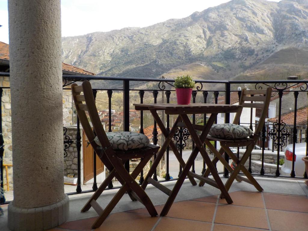 a table and chairs on a balcony with a mountain at Las Cabraliegas in Arenas de Cabrales