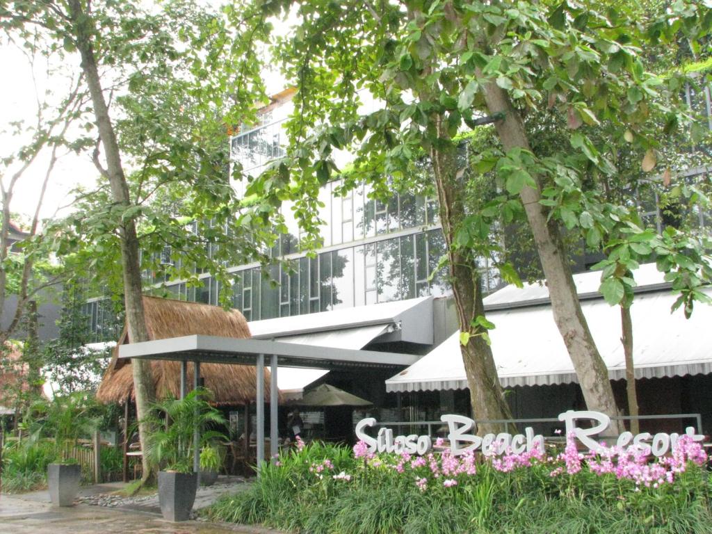 Blick auf ein Gebäude mit einem Grasdachrestaurant in der Unterkunft Siloso Beach Resort - Sentosa in Singapur