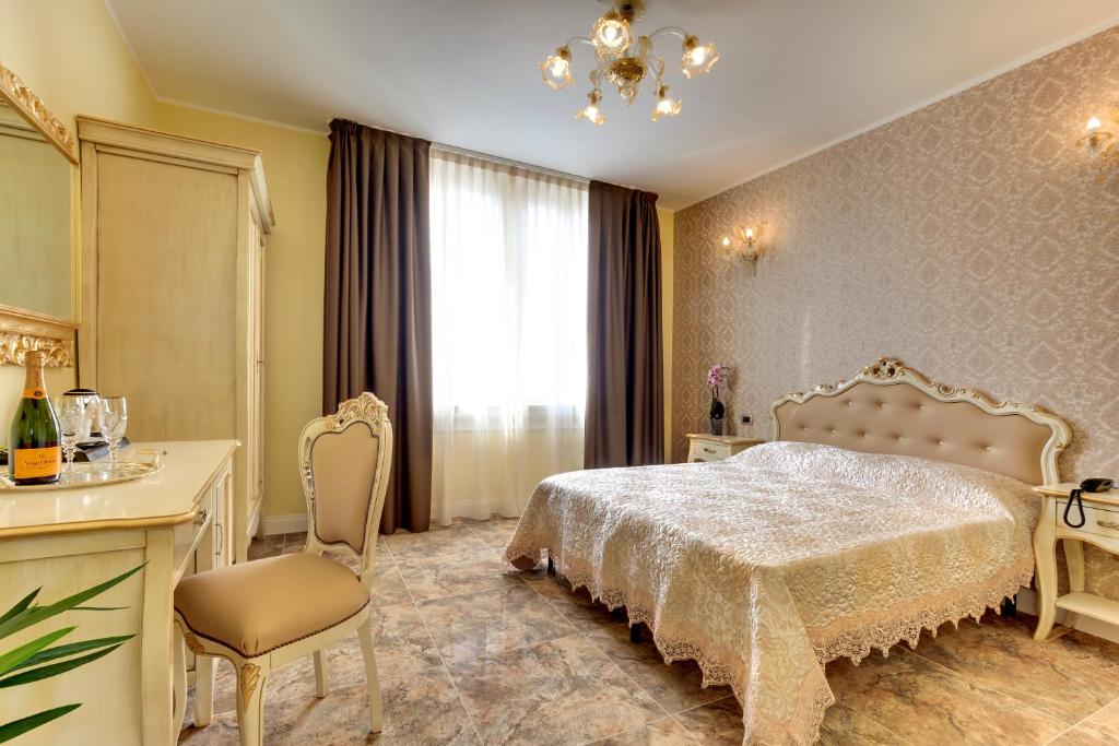 - une chambre avec un lit, une table et une chaise dans l'établissement New Reiter Hotel, sur le Lido de Venise