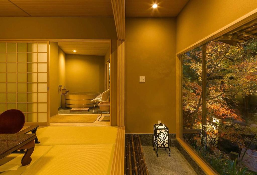 une salle de bain avec des murs jaunes et une grande fenêtre dans l'établissement Kyoto Nanzenji Ryokan Yachiyo Established in 1915, à Kyoto