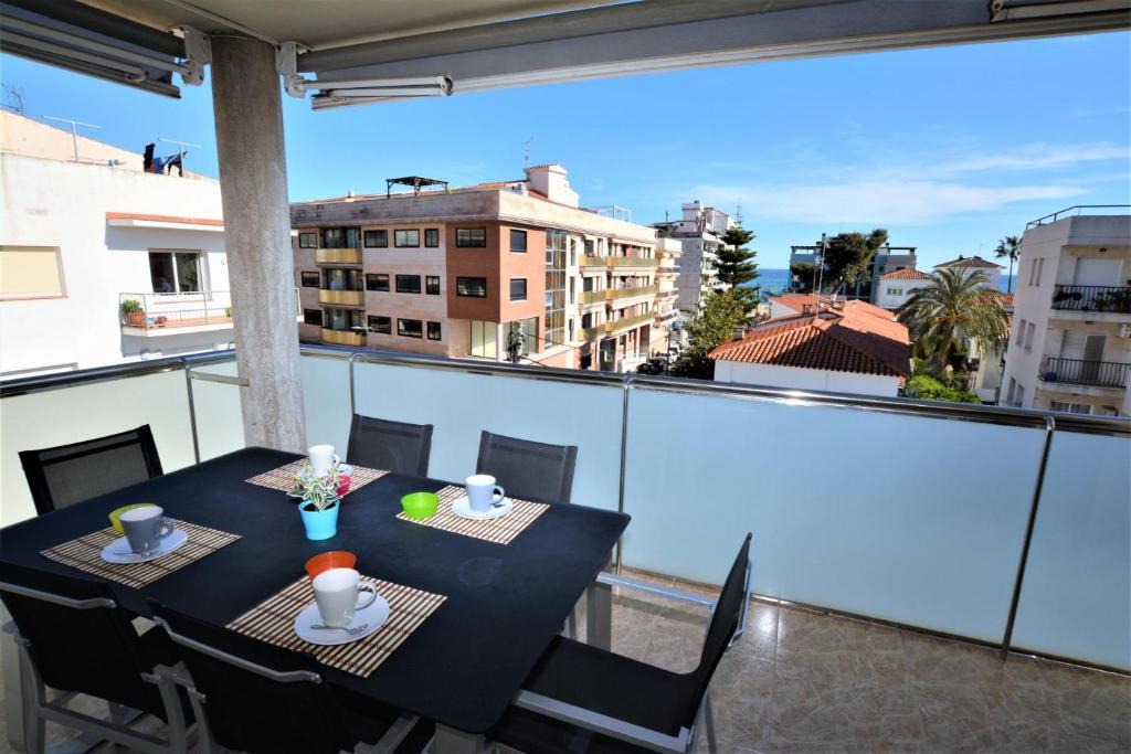 a table on a balcony with a view of a city at Villaservice - Rovior Atico in Calafell