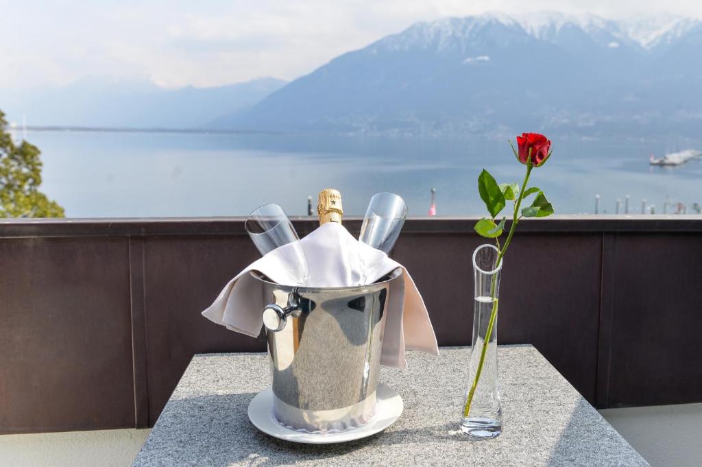 un tavolo con un secchio e un vaso con un fiore di Hotel Millennium a Locarno