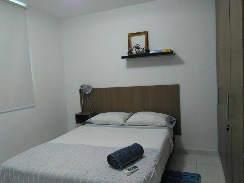 a bedroom with a bed with a blue pillow on it at CH1 Bonito apartamento amoblado en condominio RNT 1O8239 in Valledupar