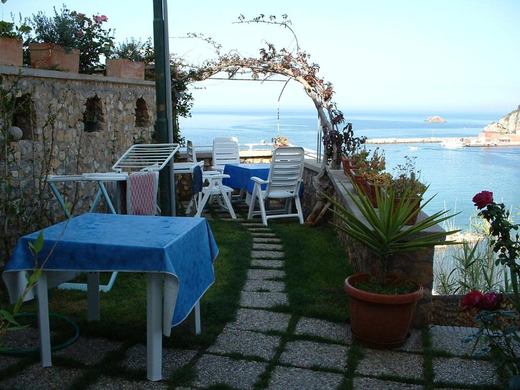 蓬扎的住宿－L'Isolana Case Vacanza Palma 1，一个带桌椅的庭院和大海