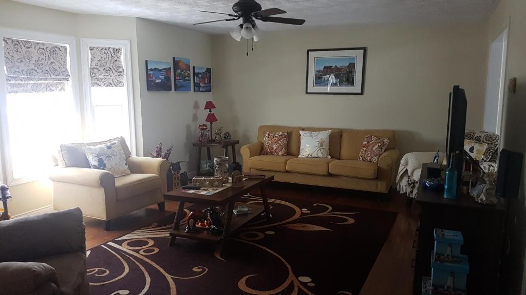 a living room with two couches and a ceiling fan at Aggie's B&B in Bonavista