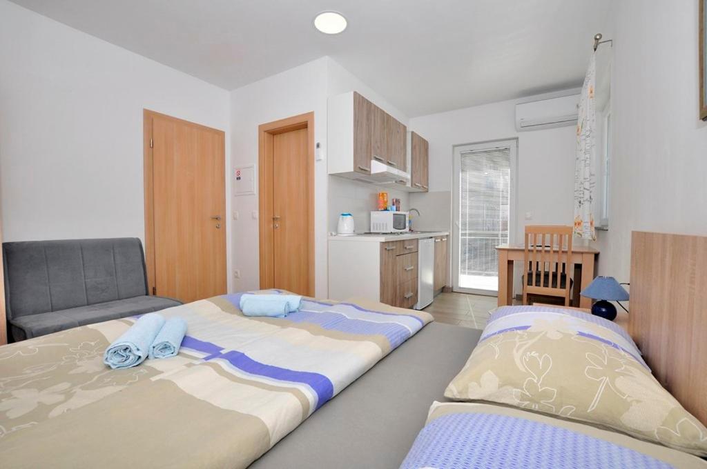 2 Betten in einem kleinen Zimmer mit Küche in der Unterkunft Apartments Valentino in Gradac