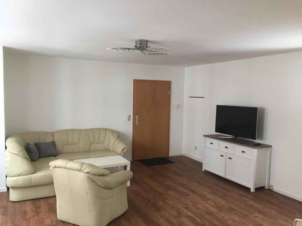 een woonkamer met een bank en een tv bij Seepferdchen in Stralsund