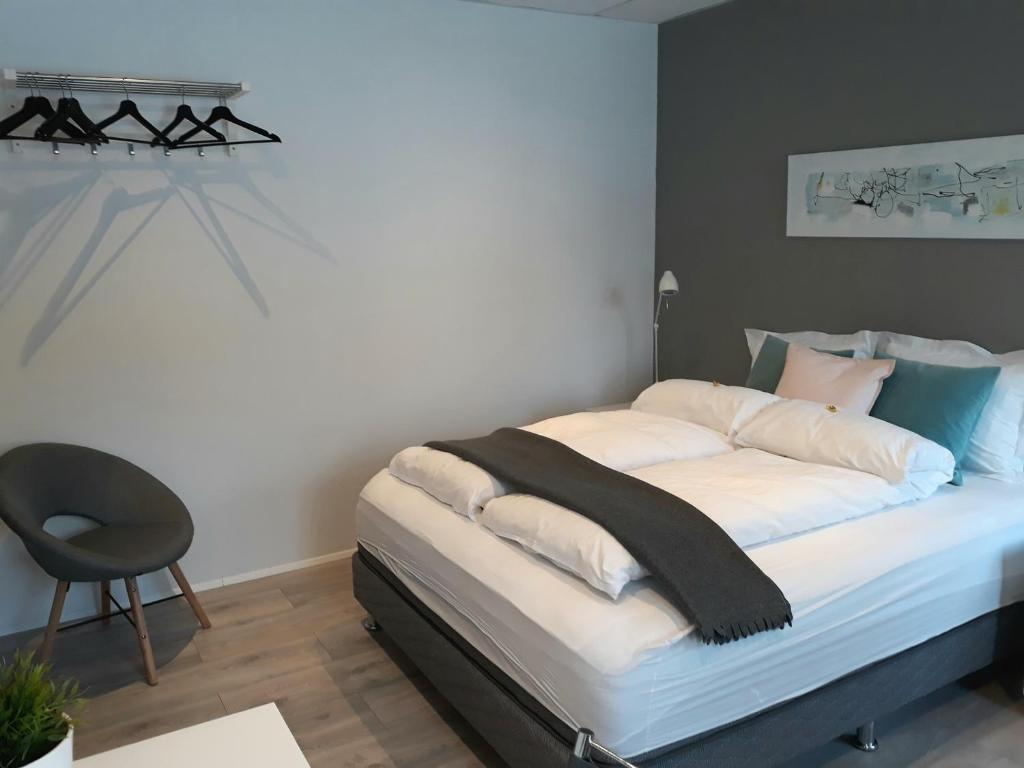 - une chambre avec un lit et une chaise à côté dans l'établissement Post-Plaza Guesthouse, à Húsavík