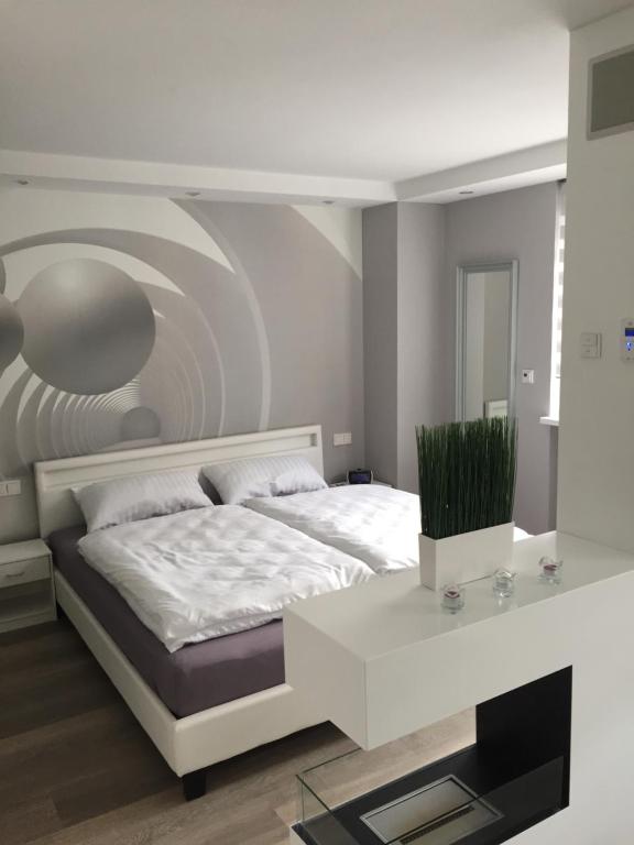 1 dormitorio con cama blanca y mesa blanca en Apartment Ferienwohnung en Sulzbach
