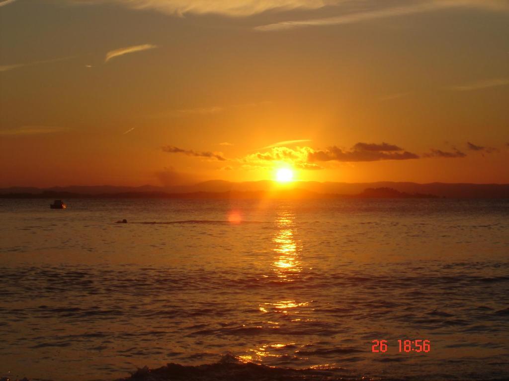 um pôr-do-sol sobre o oceano com o pôr-do-sol em Suíte Bella Vista em Barra Grande